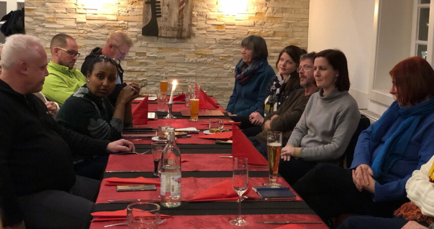 Das Foto zeigt eine Gruppe Menschen an einem Tisch in einem Restaurant.